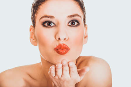 Beautiful woman with make up blowing a kiss.の写真素材