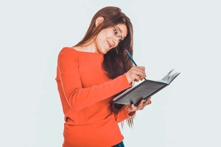 Female student writing in notebook.の写真素材