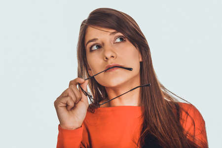 Thoughtful woman holding glasses.の写真素材