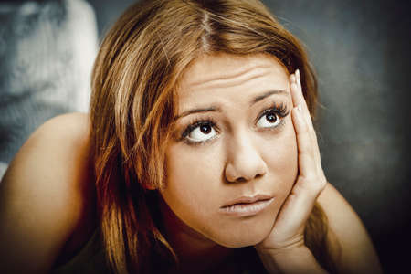 Thoughtful teenage woman looking up.の写真素材
