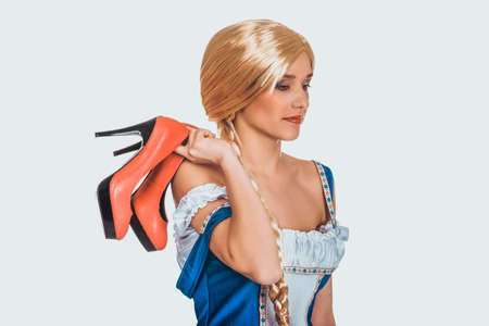 Woman in Bavarian dress holding her shoes.の写真素材