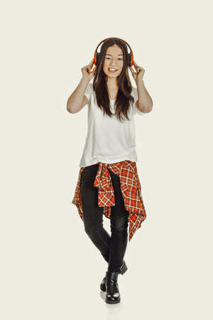 Rock woman with headphones listening to music.の写真素材
