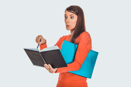 Shocked student woman with her note.の写真素材