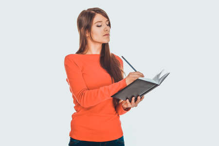 Female student writing in notebook.の写真素材