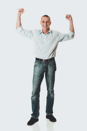 Cheerful man with hands upの写真素材