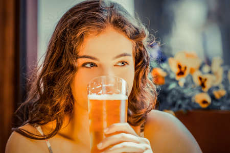 Portrait of a woman drinking beer in barの写真素材