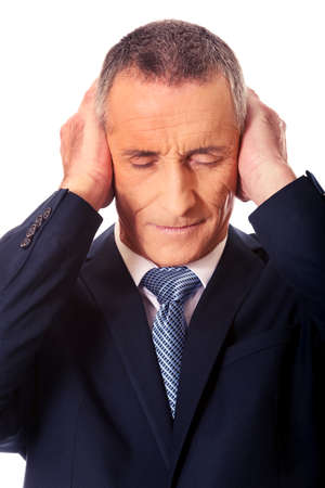 Portrait of tired man covering ears with handsの写真素材