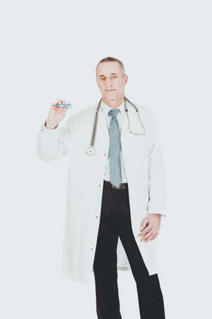 Mature male doctor holding a thermometerの写真素材