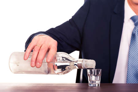 Male hand pouring vodka into a glassの写真素材