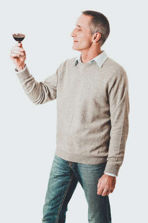 Mature man tasting red wineの写真素材