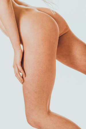 Side view naked woman touching her thighの写真素材