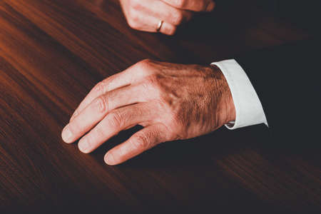 Businessmans hands put on the deskの写真素材