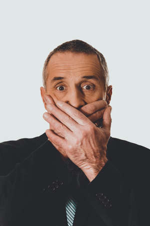 Portrait of businessman covering mouthの写真素材