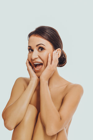 Shocked spa woman sitting with bended kneesの写真素材