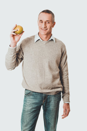 Mature man with an appleの写真素材