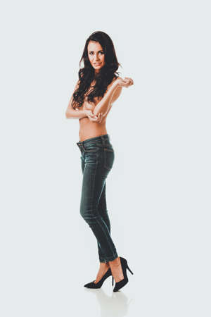 Full length shirtless woman alluring in jeansの写真素材