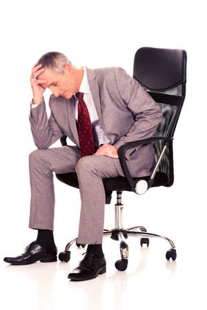 Stressed businessman sitting on armchairの写真素材
