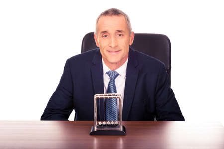 Businessman in the office with newton ballsの写真素材