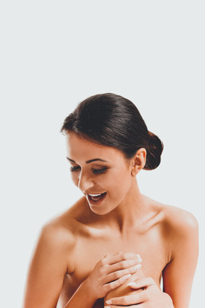 Beautiful laughing woman sitting touching kneeの写真素材