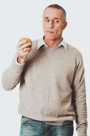 Mature man eating an appleの写真素材