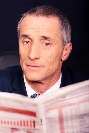 Businessman reading a newspaper in the officeの写真素材