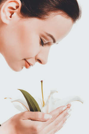 Young woman smelling white lilyの写真素材