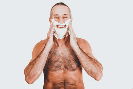 Mature man applying shaving foamの写真素材