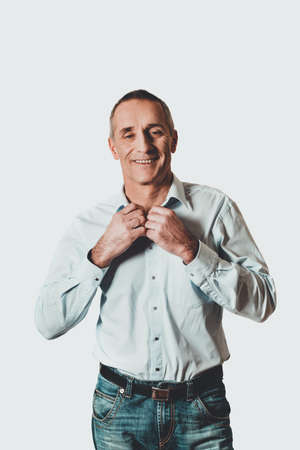 Handsome man buttoning his shirtの写真素材