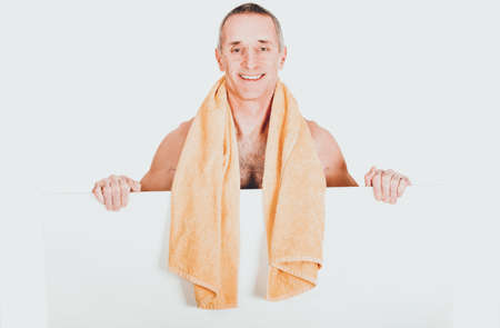Man with towel around neck holding empty bannerの写真素材