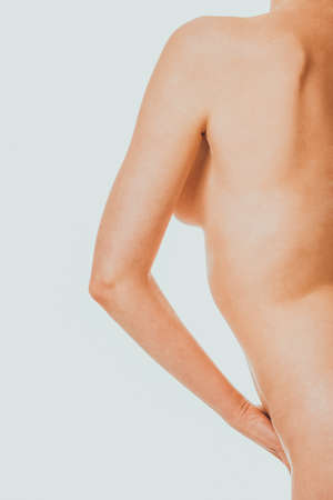 Cut out back view nude woman with hand on hipの写真素材