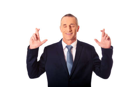 Businessman making a wish with fingers crossedの写真素材