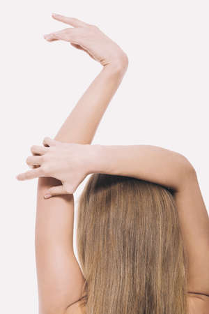 Back view of nude woman holding arms above headの写真素材