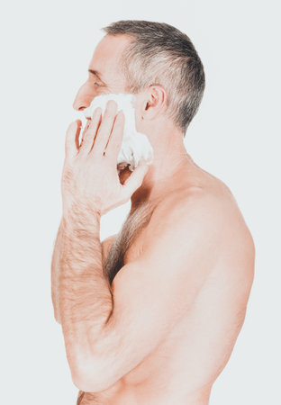 Mature man applying shaving foamの写真素材