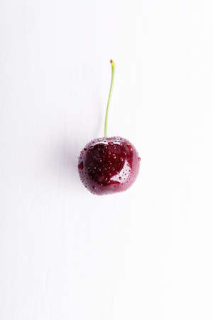 Wet fresh juicy single cherry.の写真素材