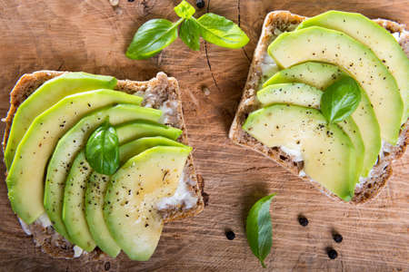 Sandwich with avocado slices and basil.の写真素材