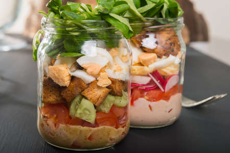 Two glass jars with fresh salad.の写真素材