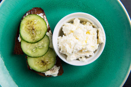 Single sandwich with cream cheese and cucumber and cream cheese in bowlの写真素材