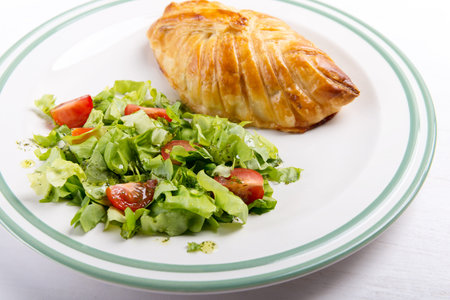 Chicken breast in french pastry with fresh salad.の写真素材