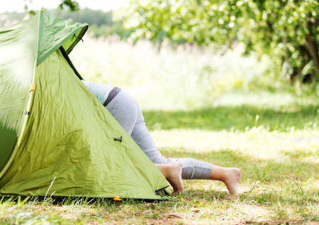 Young woman resting in a tent on the natureの写真素材