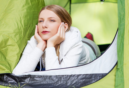 Young woman resting in a tent on the natureの写真素材