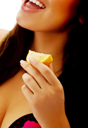 Young beautiful woman eating raw shellfish with lemonの写真素材