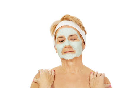 Relaxed elderly woman in facial maskの写真素材