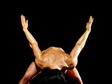 Muscular naked bodybuilder woman showing her muscles over black background.の写真素材
