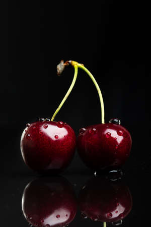 Two juicy fresh wet cherries.の写真素材