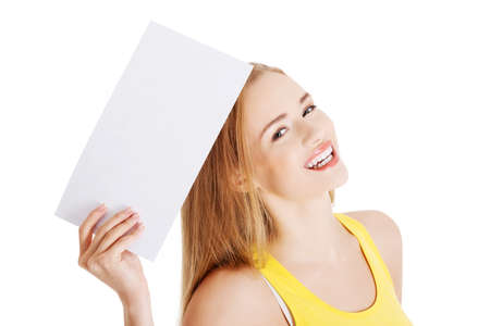 Attractive casual caucasian woman holds empty white piece of paper.の写真素材
