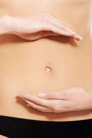Close up on females belly with hands.の写真素材