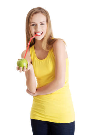 Beautiful caucasian casual slim woman drinking juice from an apple with straw.の写真素材