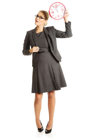 Surprised businesswoman holding a big clockの写真素材