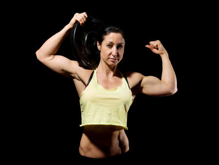 Muscular bodybuilder woman showing her muscles.の写真素材
