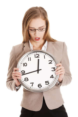Young caucasian business woman holding clock.の写真素材